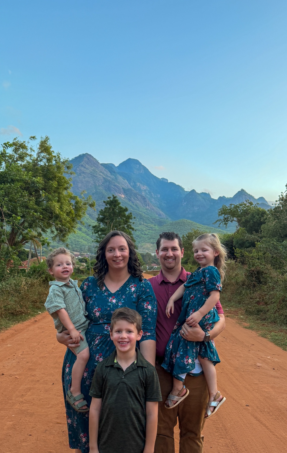 The Robb family on a road in Tanzania with the mountains behind them